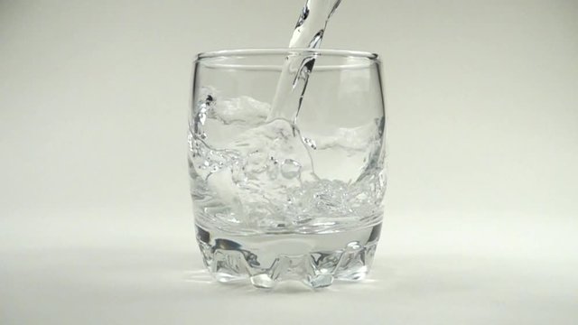 	Water is poured in a glass. Slow motion. 