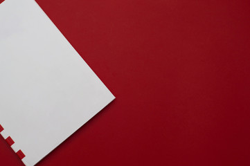 Front view of the white with red stripes memo pad part on the plain red background