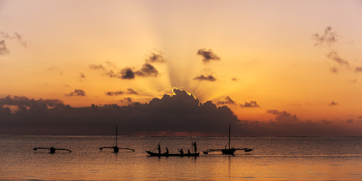 male fisherman floats on a wooden boat in the ocean, Wooden boat on the waves of the ocean, fisherman, Coast of Mombasa, Kenya, ocean, clouds, coast, Mombasa,fishermen 