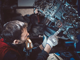 Fototapeta na wymiar Closeup repair of an opposing engine by an auto mechanic.