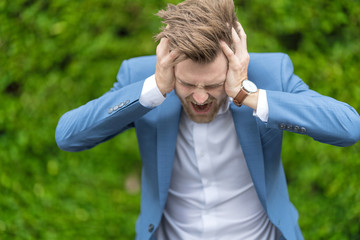 young bearded business man in blue suit feeling stressed