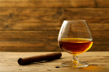 cognac o brandy bicchiere con bevanda alcolica su sfondo legno rustico