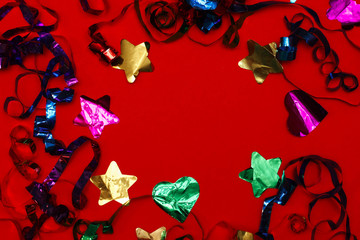 top view of confetti and sequins on a red background