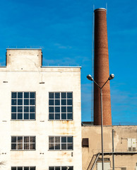 White old factory. Brown chimney and streetlight. Clear sky and sunny day. Kaunas city