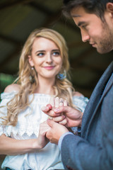 Portrait of the young adorable couple in love, man holding hands of his woman indoors