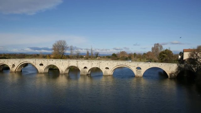 Arched Old Bridge over Orb river and medieval cathedral of Saint Nazaire in Beziers
