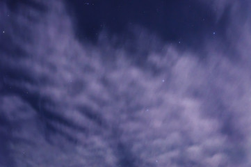 White clouds illuminated in the moonlight . The night sky winter night.