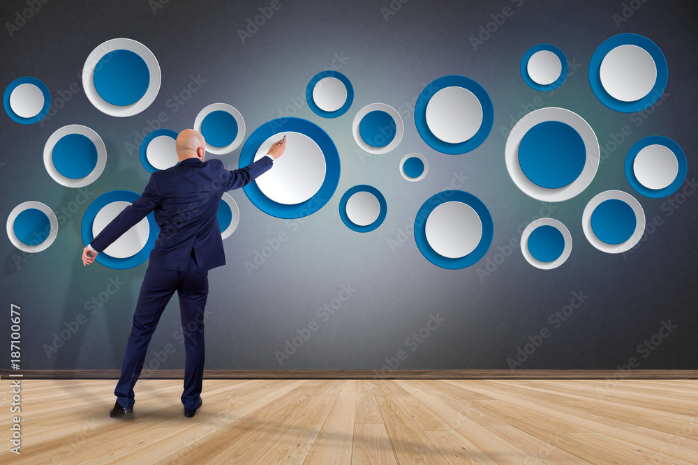 Poster businessman in front of a wall with empty app interface made of blue button displayed on a interface