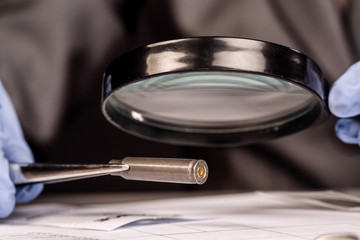 Detective through a magnifying glass looking at a evidence