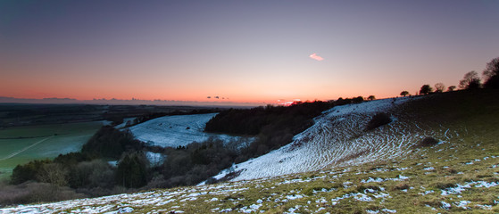 After sunset on a clear winters evening with rising full moon - view of grazing cattle on Beacon Hill looking at the South Downs and Old Winchester Hill in the background