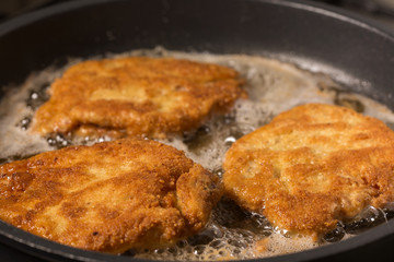 Frying wiener schnitzel in a hot pan