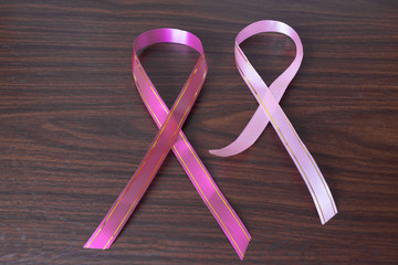 World Cancer Day: A ribbon of awareness of cancer on a wooden background