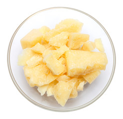 Parmesan cheese pieces in glass bowl on white background