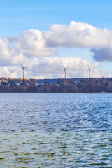 Fototapeta na wymiar Wind turbines above Lake Starnberg on a sunny day