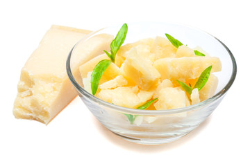 Parmesan cheese pieces in glass bowl on white background