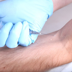 Man's hand enters the cure , the vaccine syringe in hand