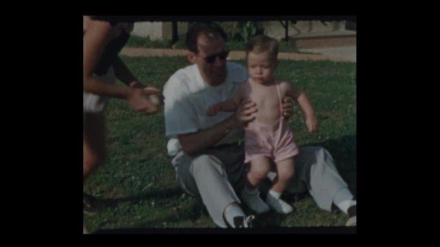 1953 Father playing ball outside with daughter and infant son