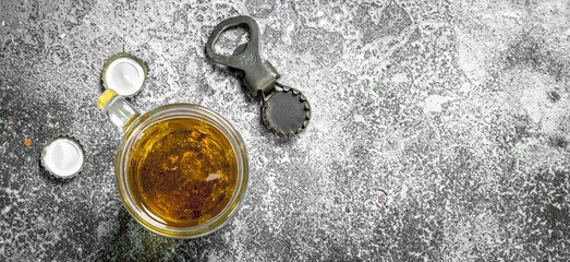 glass of beer with a bottle opener and stoppers.