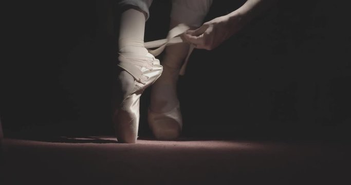 Ballerina wears ballet shoes