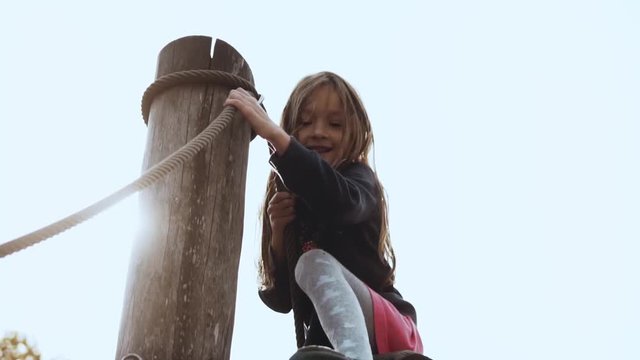 Portrait of little adorable girl on playground. Cute smiling 6 year old girl goes over obstacles on showground cheerful.