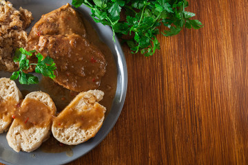 Pork loin in gravy with bread dumplings and sauerkraut