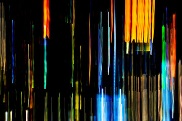Abstract of multicolored city lights beams in motion, Moving colorful lines or light painting LED building abstraction on busy city Light trails, Rainbow and chaos black background. Vertical desigh