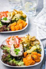 Baked fish steak and parmesan roasted  harvest vegetables. Selective focus, copy space.