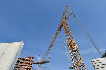 Baugerüst vor Neubau Betonwand / Baustelle mit Baukran