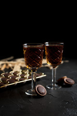 glasses with wine, chocolate and fruit on a dark background