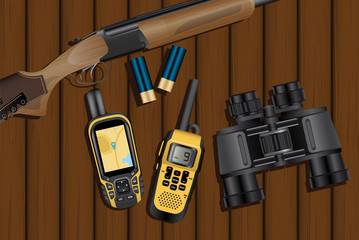 Hunting rifle, cartridges, navigator, walkie-talkie and binoculars on a wooden table