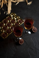 glasses with wine, chocolate and fruit on a dark background