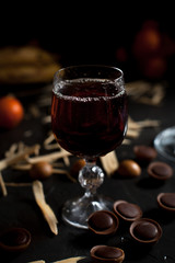 glasses with wine, chocolate and fruit on a dark background