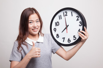 Young Asian woman thumbs up with a clock.