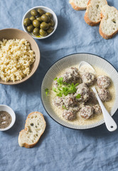 Lamb meatballs in a yogurt sauce and bulgur - yummy healthy lunch in a mediterranean style on a blue background, top view