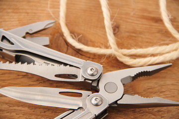 Multifunktionswerkzeug mit Faden auf einem Brett