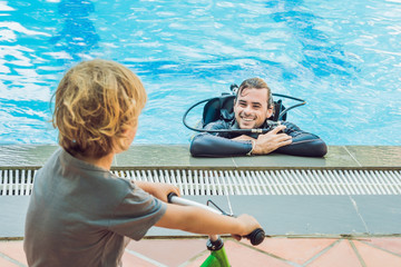 scuba diver in swimming pool and boy