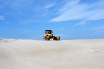 Fototapeta na wymiar Planierraupe im Einsatz im Sand