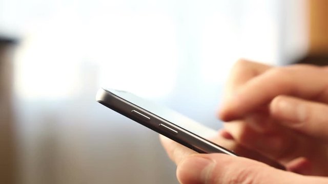 Close-up on finger scrolling and stretching screen on smartphone.