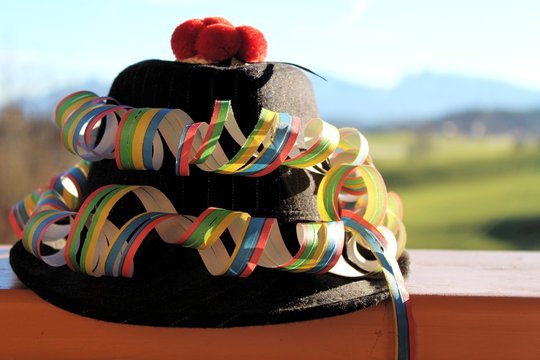 Hut auf dem Balkon, dekoriert mit Luftschlangen für den Karneval, Landschaft im Hintergrund