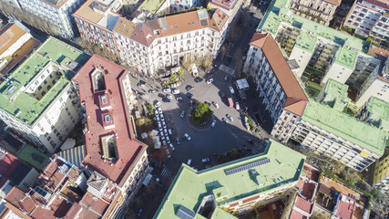 Aerial view of Piazza Vanvitelli in the Vomero district in Naples, Italy. In this roundabout, with a tree in the middle, many cars pass every day. Around there are houses and buildings.
