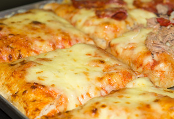 Rectangular shape and thick hand made focaccia pizza. Close-up. Food, italian cuisine and cooking concept. Preparation of the Italian Pizza