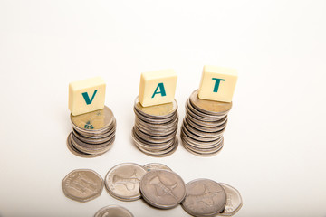 Stacks of coins with the letters VAT  (Value Added Tax) isolated on white background