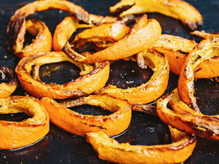 Vegetarian and healthy food: baked in a country oven slices of fragrant pumpkin