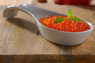 Sandwich with red caviar and on a metal spoon