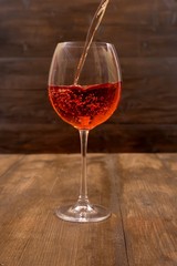 A glass of pink wine on a dark background