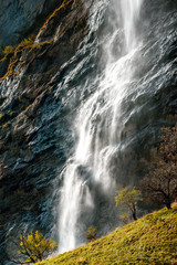 Beautiful autumn time at village of Lauterbrunnen in Swiss alps, gateway to famous Jungfrau. Set in a valley featuring rocky cliffs and the roaring, 300m-­high Staubbach Falls