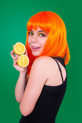 Portrait of red-haired woman in studio close-up with lemon.