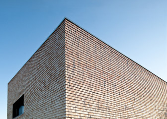 Fototapeta na wymiar Moderne Holzfassade aus Schindel gegen blauen Himmel, Datailansicht