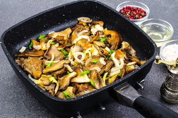 Oyster mushrooms fried with onions in frying pan