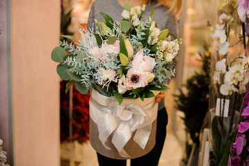 female holds a bouquet with roses, eustoma, succulents, eucalyptus